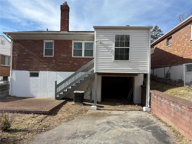 rear view of property with central AC