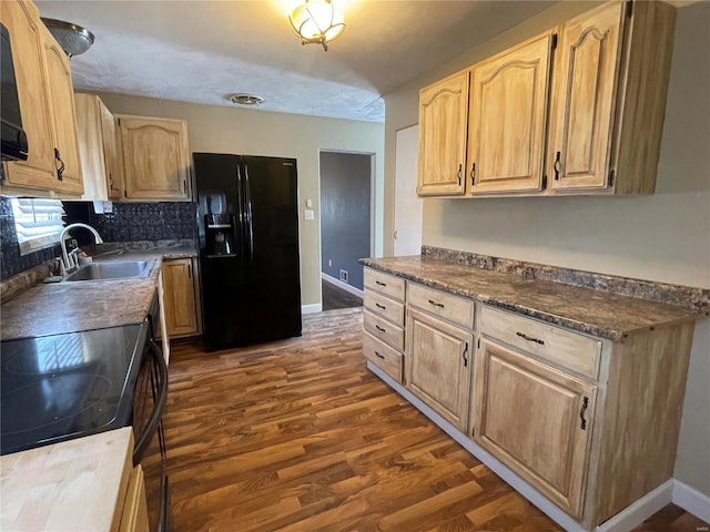 kitchen with sink, light brown cabinets, dark wood-type flooring, and black appliances