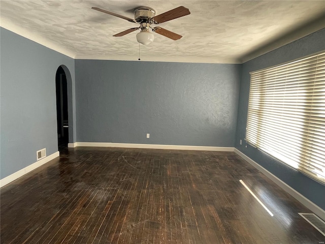 empty room featuring ceiling fan, dark hardwood / wood-style floors, and a textured ceiling