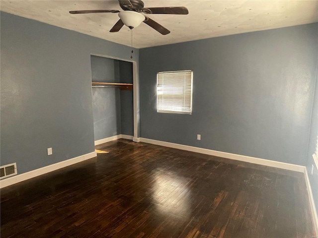 unfurnished bedroom with dark wood-type flooring, ceiling fan, and a closet