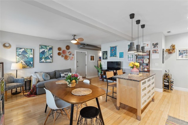 dining room with light wood-type flooring, baseboards, and a ceiling fan