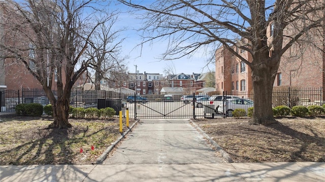 view of street featuring curbs, a gated entry, and a gate