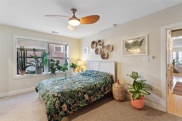 bedroom with visible vents, carpet floors, baseboards, and a ceiling fan