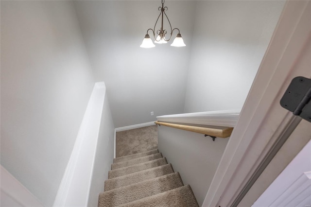 stairs featuring carpet and a notable chandelier