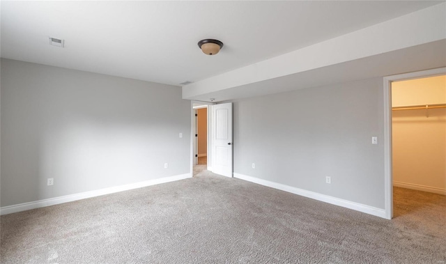 unfurnished bedroom featuring a walk in closet, carpet, and a closet