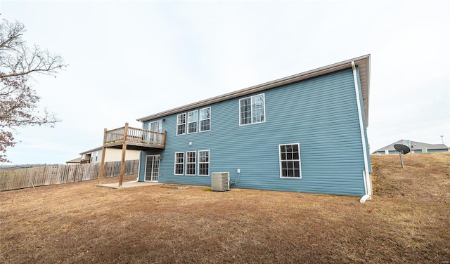 rear view of house featuring a yard and central air condition unit