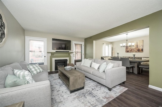 living room featuring an inviting chandelier, hardwood / wood-style floors, and a textured ceiling