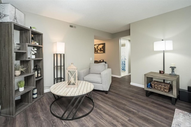 sitting room with dark wood-type flooring