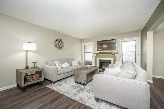 living room with dark hardwood / wood-style floors and a textured ceiling