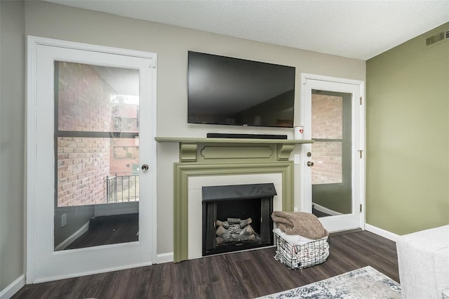 living room with dark hardwood / wood-style flooring and a textured ceiling