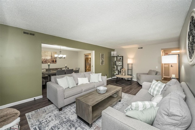 living room featuring wood-type flooring, a textured ceiling, and a notable chandelier