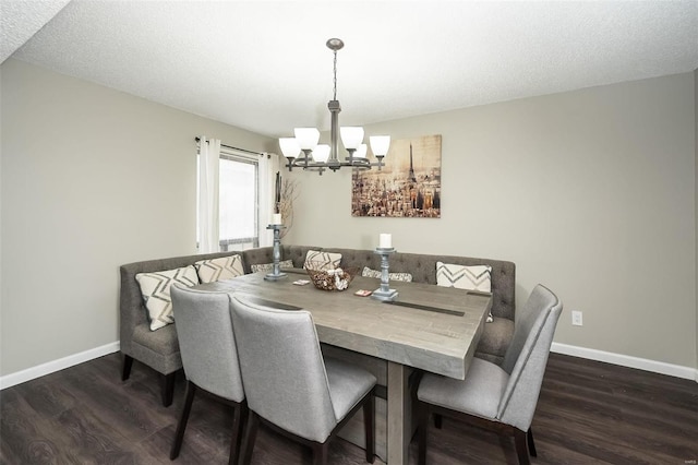 dining space with dark hardwood / wood-style flooring, a notable chandelier, and a textured ceiling