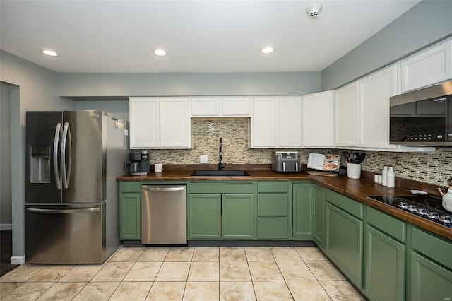 kitchen featuring sink, tasteful backsplash, wooden counters, light tile patterned floors, and stainless steel appliances