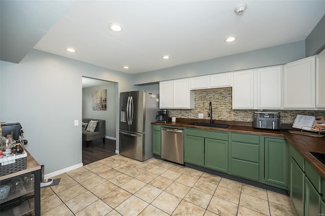 kitchen featuring white cabinetry, appliances with stainless steel finishes, sink, and butcher block countertops