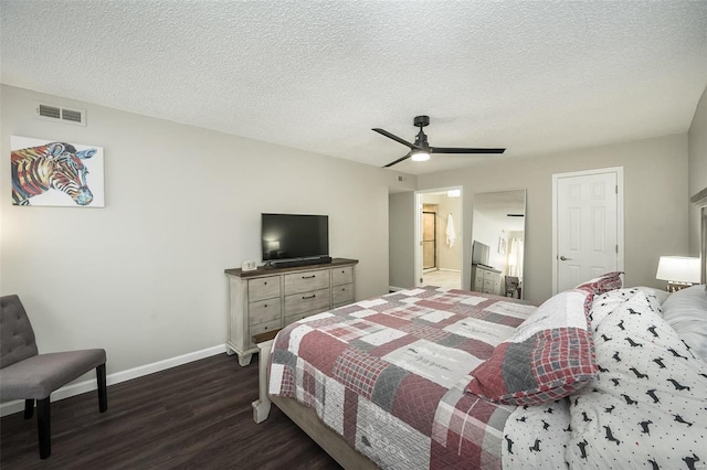 bedroom featuring dark wood-type flooring, ceiling fan, ensuite bathroom, and a textured ceiling