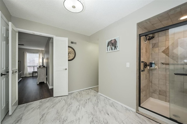 bathroom with a shower with door and a textured ceiling