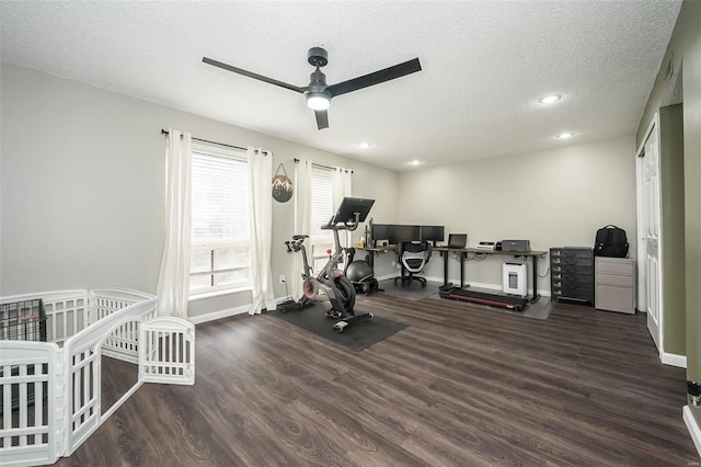 exercise room featuring ceiling fan, dark hardwood / wood-style floors, and a textured ceiling