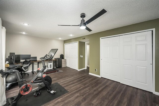 exercise room with dark wood-type flooring, ceiling fan, and a textured ceiling