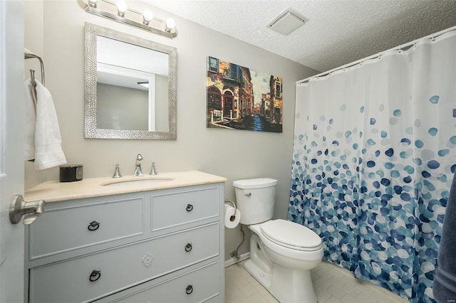 bathroom with vanity, a textured ceiling, and toilet