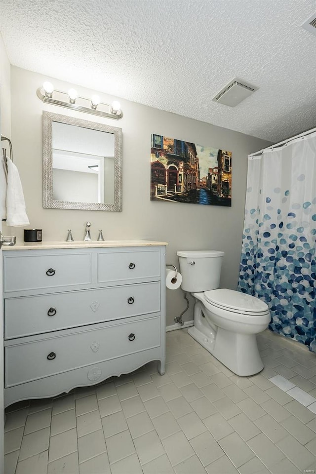 bathroom featuring a shower with curtain, vanity, toilet, and a textured ceiling