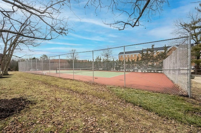 view of tennis court featuring a yard