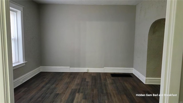 spare room with dark wood-type flooring