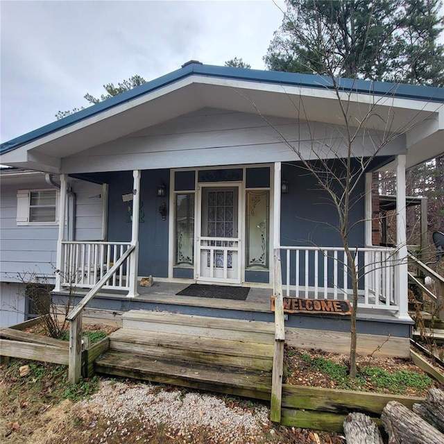 view of exterior entry featuring covered porch