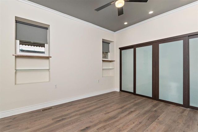 unfurnished bedroom featuring ornamental molding, dark wood-type flooring, ceiling fan, and a closet