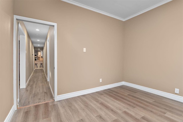 empty room with light hardwood / wood-style flooring and ornamental molding