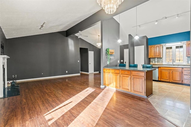 kitchen featuring light wood-style floors, a fireplace, open floor plan, and a sink