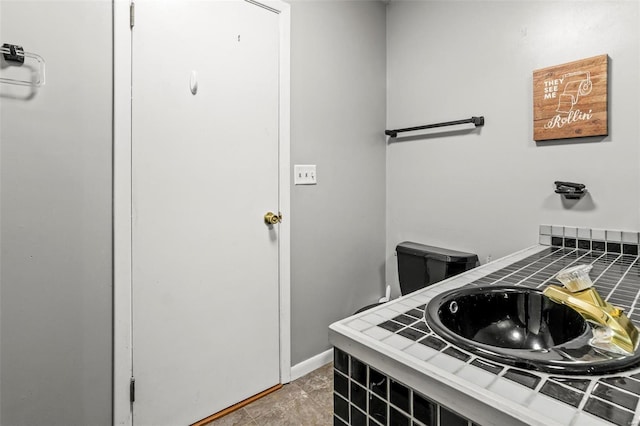 bathroom featuring toilet, vanity, and baseboards