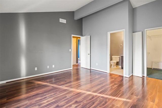 unfurnished bedroom featuring beam ceiling, dark wood-style flooring, visible vents, and baseboards