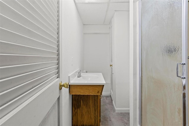 full bathroom featuring a stall shower, baseboards, and vanity