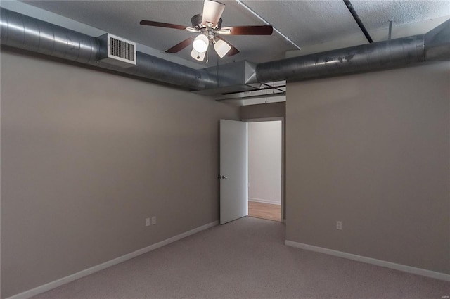 basement with ceiling fan and light carpet