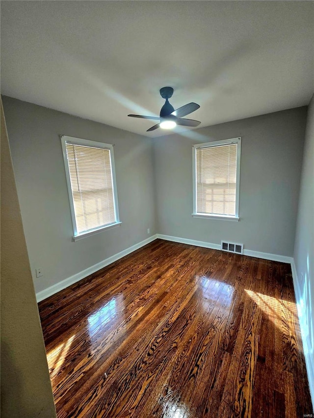 spare room with ceiling fan and dark hardwood / wood-style flooring