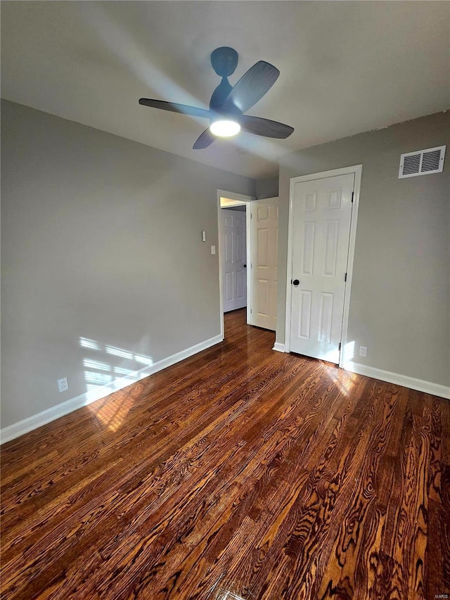 unfurnished bedroom with dark wood-type flooring and ceiling fan