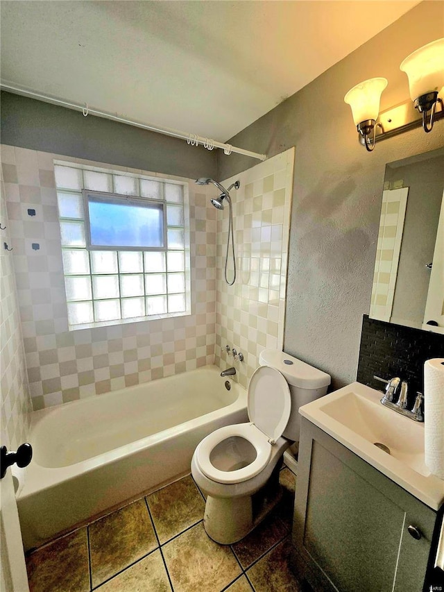 full bathroom featuring tiled shower / bath combo, vanity, tile patterned floors, and toilet