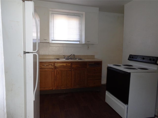 kitchen with dark wood-type flooring, white appliances, and sink