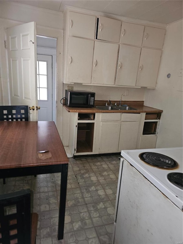 kitchen featuring white electric range, sink, and white cabinets