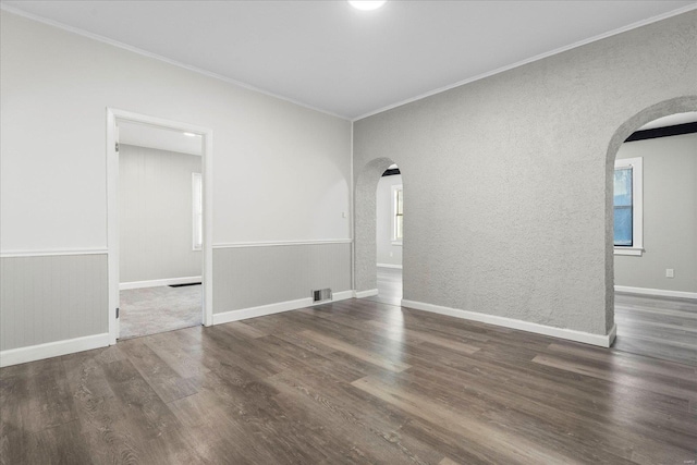 spare room featuring ornamental molding and dark wood-type flooring