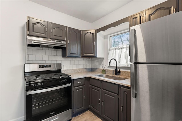 kitchen featuring stainless steel appliances, sink, light hardwood / wood-style flooring, and backsplash