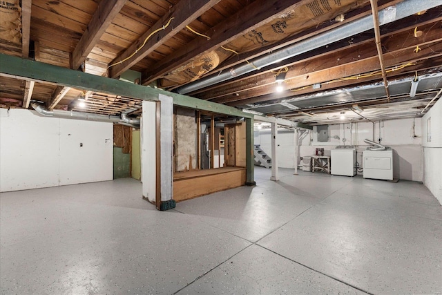 basement featuring electric panel and washing machine and clothes dryer