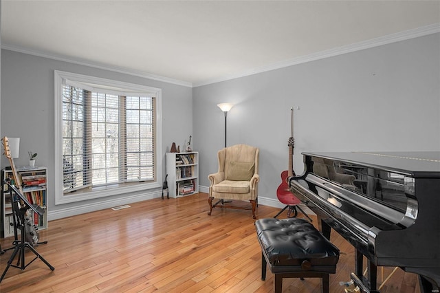 sitting room with crown molding, baseboards, and wood finished floors