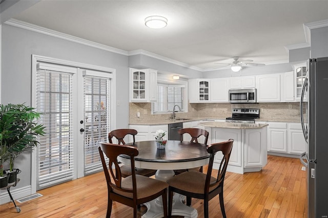 dining room with light wood finished floors, visible vents, french doors, and crown molding