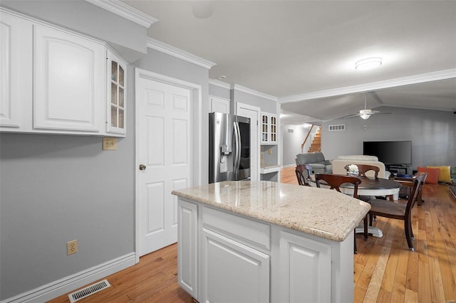 kitchen featuring visible vents, light wood-style floors, glass insert cabinets, stainless steel refrigerator with ice dispenser, and white cabinetry