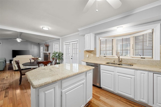 kitchen with light wood finished floors, dishwasher, ornamental molding, a fireplace, and a sink