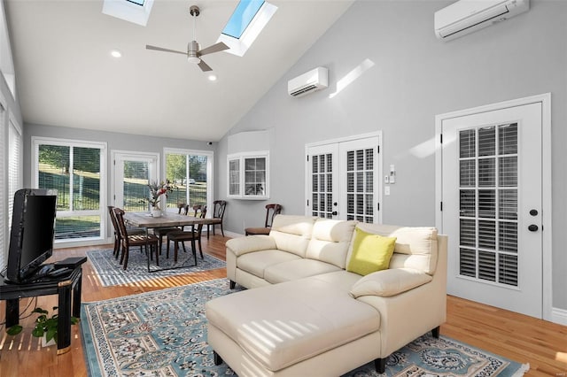 sunroom / solarium featuring an AC wall unit, vaulted ceiling with skylight, french doors, and ceiling fan