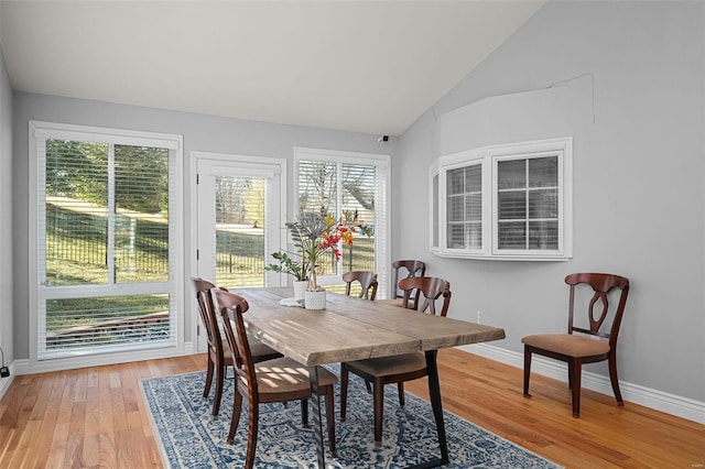 dining room featuring vaulted ceiling, baseboards, and light wood finished floors