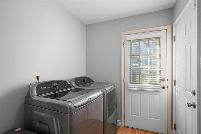 laundry room with washing machine and clothes dryer, laundry area, and light wood-type flooring