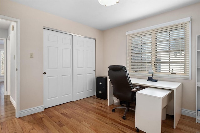 office featuring baseboards and light wood-style flooring